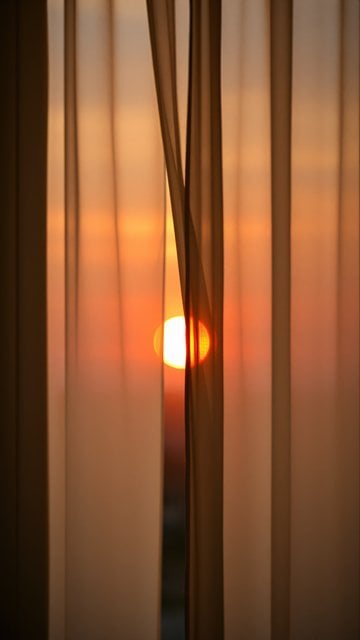 Warm Sunset Glow Through Sheer Curtains