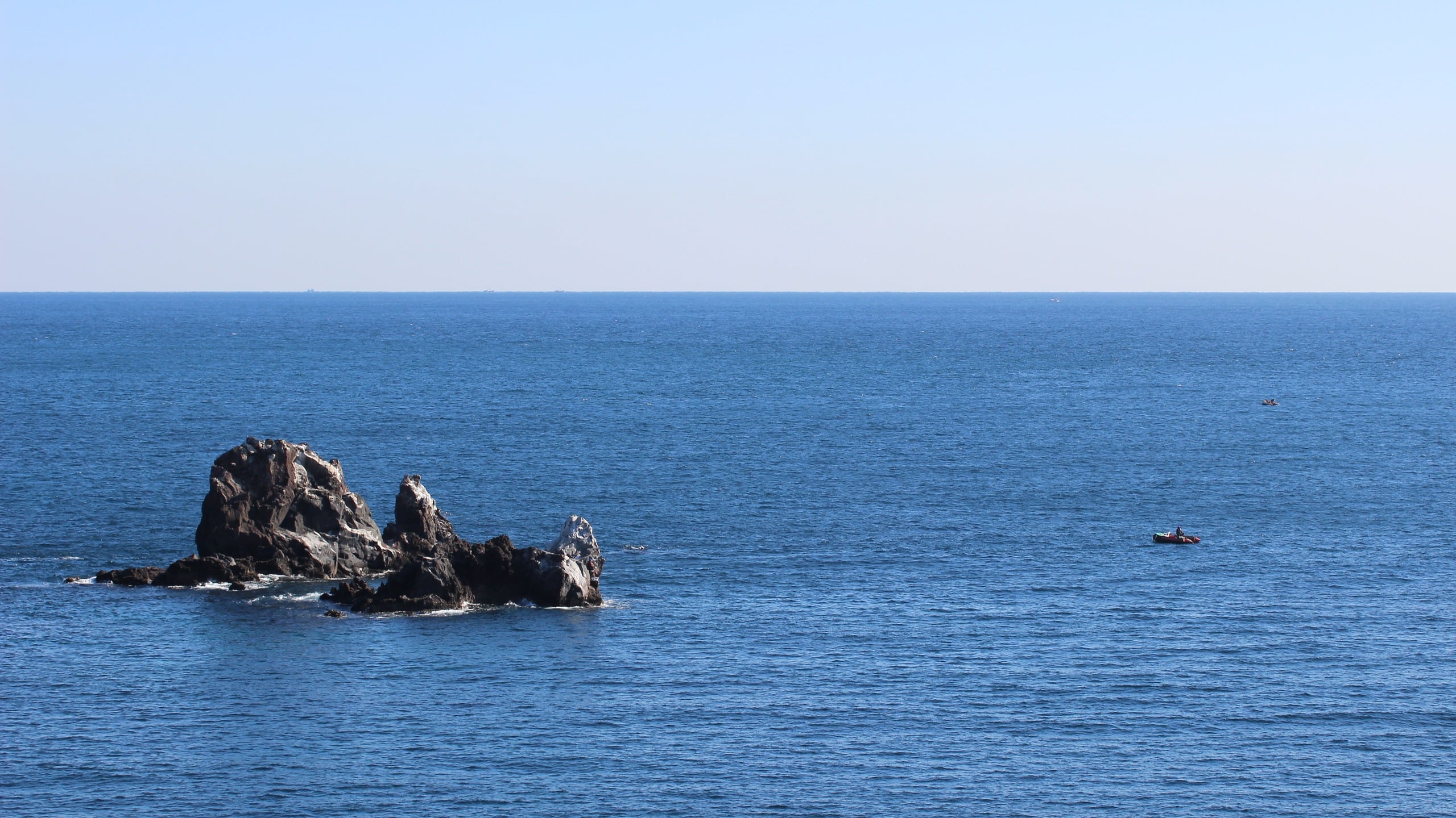 Ocean Rocks and Small Boats under Clear Sky, ocean, sea, rocks, blue, sky, boat
