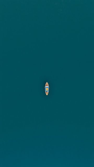 Minimalist Teal Water with Lone Wooden Boat