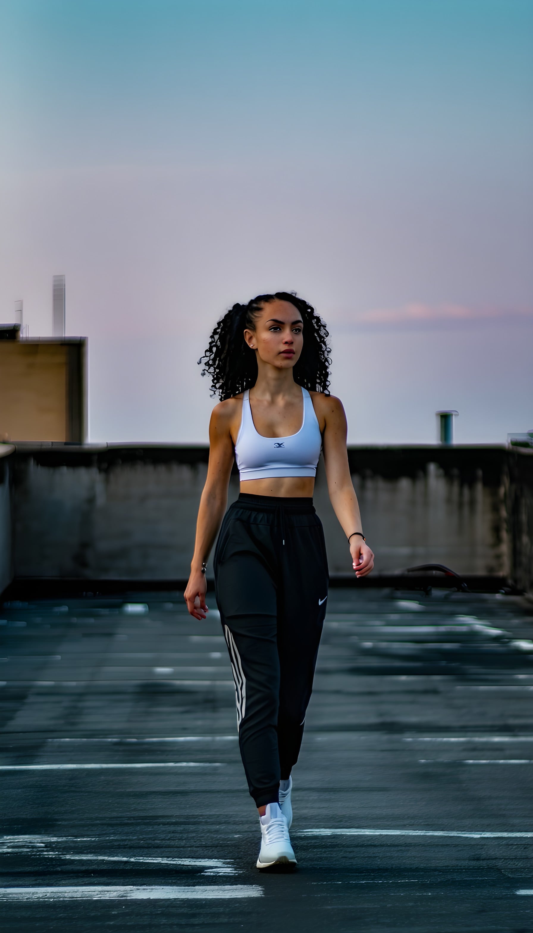 Urban Athlete Rooftop Twilight Walk, urban fitness, rooftop walk, athletic woman, twilight sky, fitness fashion, black and white